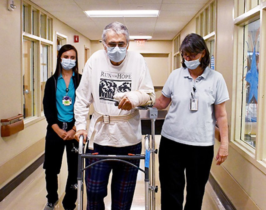 Wallace Strickland practices walking in the hallway of Methodist Rehabilitation Center with, from left, Marguerite Marquez, a University of Alabama/Birmingham physical therapy student, and MRC physical therapist Mary Smith.